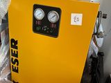 a yellow air compressor sitting on top of a pallet
