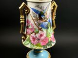 un vase orné d'un oiseau et de fleurs