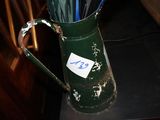 un vase vert contenant des parapluies, posé sur une table