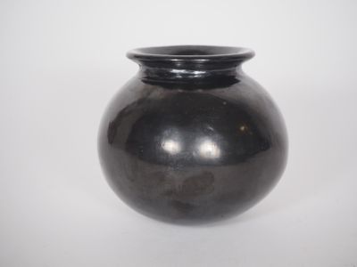 a black vase that is sitting on a white surface