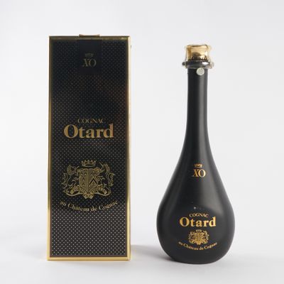a bottle of ouard is next to a box on a white surface