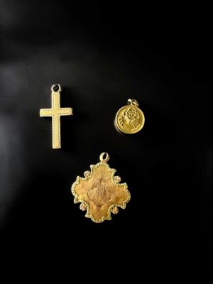 un gros plan d'une croix et d'une médaille sur une surface noire