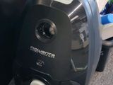 un aspirateur noir et blanc posé par terre près d'un mur noir