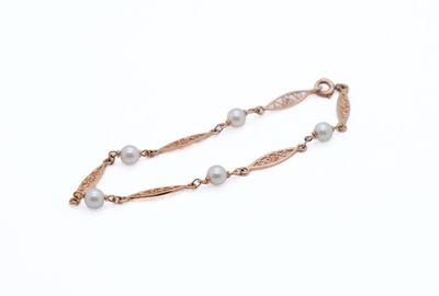a close up of a bracelet with pearls on a white background