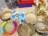 many different bracelets and rings on a tray