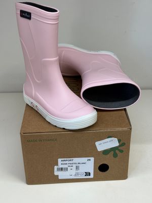 une paire de bottes de pluie roses posée sur une boîte en carton