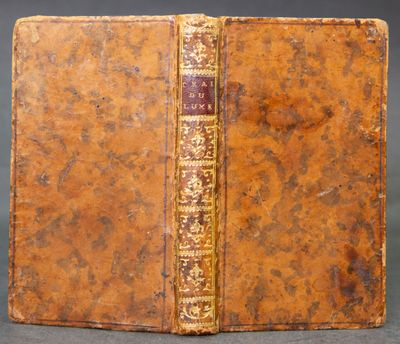 an old book with a brown cover and gold trim