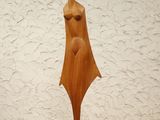 wooden sculpture of a woman standing on a wooden table
