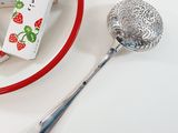 a bowl of strawberries next to a spoon and a box of candy
