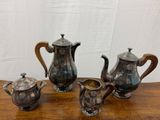 un service à thé et à café en argent ancien composé de quatre pièces, posé sur une table en bois