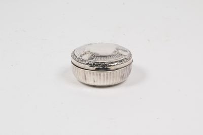 a close up of a small silver container on a white surface