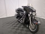 une photo d'une moto noire garée sur un sol à damier