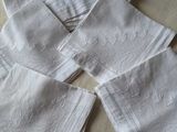 quatre serviettes en lin blanc sur une table recouverte d'une nappe blanche