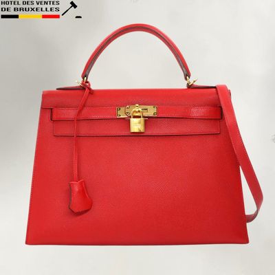 un sac à main en cuir rouge muni d'un fermoir doré sur la poignée