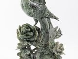 une statue représentant un oiseau perché sur une branche d'arbre