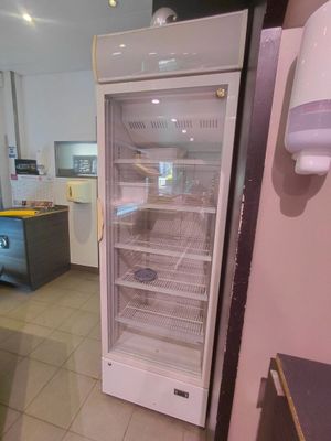 un réfrigérateur ouvert dans une cuisine au sol carrelé