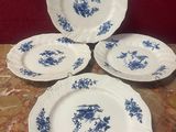 quatre assiettes bleues et blanches ornées de fleurs, posées sur une table