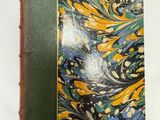 un vieux livre posé sur une table blanche à côté d'un mur blanc