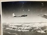 a black and white photo of a plane flying above the clouds