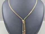 un collier en or orné d'un pompon autour du cou d'un mannequin