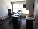 a desk with a computer and a chair in a room