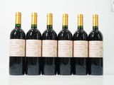 six bouteilles de vin sont alignées sur une table