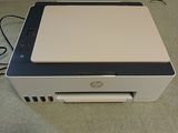 a white printer sitting on the floor next to a window