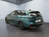 the rear end of a green car parked in a garage