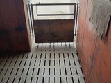 a horse stall with a door open and a towel hanging on the door