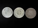 three different types of coins on a black background