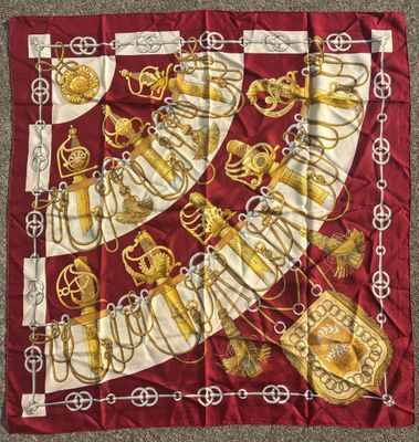 a close up of a red and gold scarf on a carpet