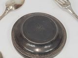 a silver plate with a silver spoon and spoon rest on it