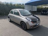 a small silver car parked in a parking lot