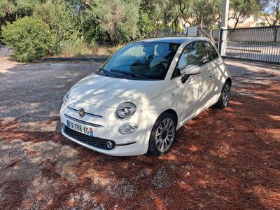 une petite voiture blanche garée sur le bord de la route
