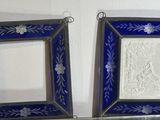 two picture frames hanging on the wall next to each other
