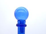 a blue glass bottle with a blue stopper on it