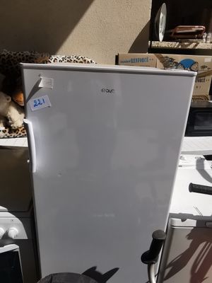 un réfrigérateur blanc posé sur une table avec d'autres appareils électroménagers