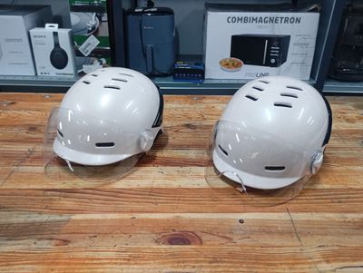 two helmets that are sitting on a wooden table