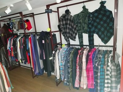 beaucoup de vêtements suspendus à une étagère dans un magasin