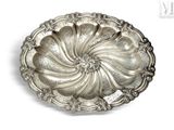 an antique silver plate on a white background with a tag on it