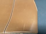 a close up of a brown leather bag on a table