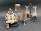 une figurine représentant un homme assis devant une collection de vases