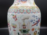a white vase with colorful designs on it on a black surface