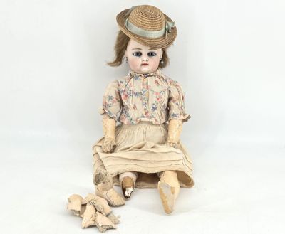 a doll that is sitting on the ground with a hat on
