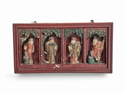 three wooden statues of buddhas in a display case
