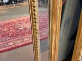 a mirror that is sitting on the floor in front of a chair