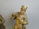 deux figurines d'un homme et d'une femme assis sur un banc