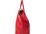 a red leather tote bag sitting on top of a white surface