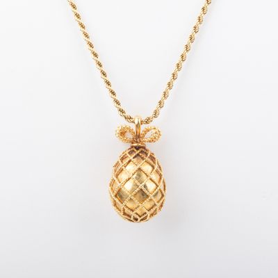 a gold pineapple pendant on a gold chain