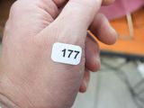 a person holding a white sticker with the number 17 on it